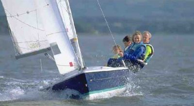 group of 4 people on a blue sailing dinghy learning to sail with Mylor Sailing School