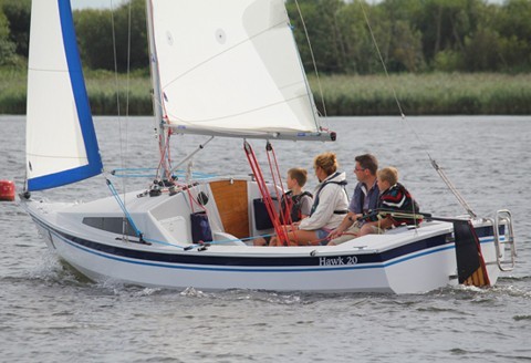 Family sailing on an accessible sailing boat at Mylor Sailing School near Falmouth, Cornwall