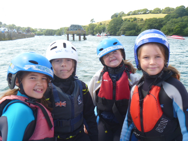 Four children with helmets on ready for sailing at Mylor Sailing School in Cornwall