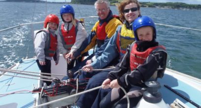 Family of five learning to sail on a keelboat in Mylor Cornwall