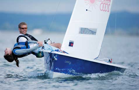 Two people hiking out a lot in a Laser 2000 sailing dinghy at Mylor Sailing School in Falmouth, Cornwall