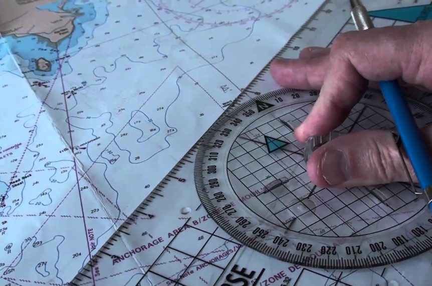 Portland plotter on a chart with someone's hand at Mylor Sailing School Cornwall