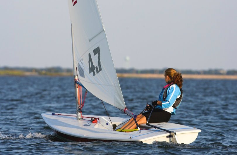 Teenage girl sailing a Laser 4.7 on a sunny day at Mylor Sailing School near Falmouth, Cornwall