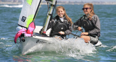 Two teenage girls having fun sailing a RS Feva dinghy on a sunny day at Mylor Sailing School near Falmouth, Cornwall