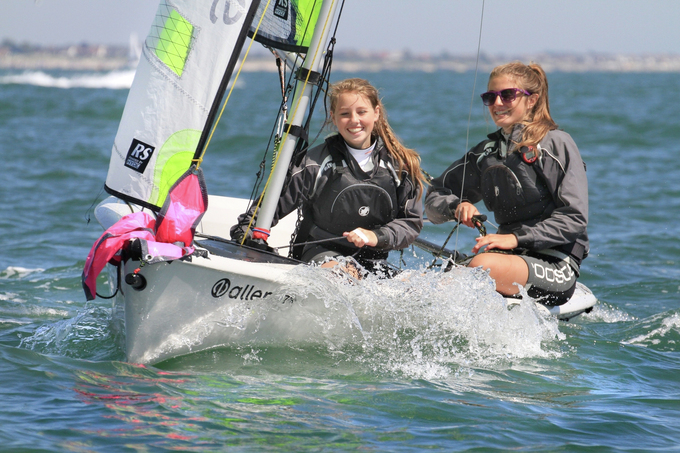 Two teenage girls having fun sailing a RS Feva dinghy on a sunny day at Mylor Sailing School near Falmouth, Cornwall