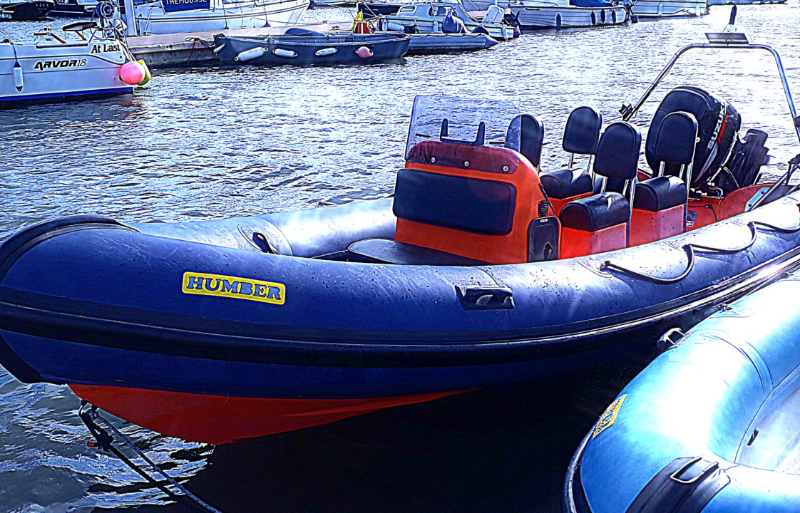 Blue and orange Humber RIB with 4 seats in the water at Mylor Sailing School Falmouth Cornwall