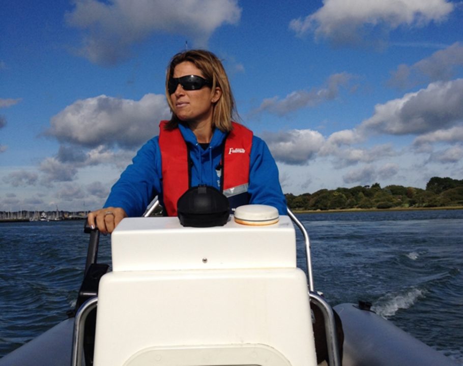 Lady with sunglasses on driving a RIB at Mylor Sailing School Falmouth Cornwall