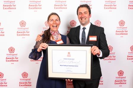 Tracey and Al receiving a framed award from Visit England