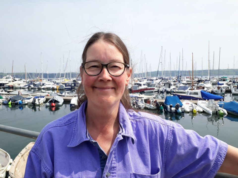 Shorebased trainer lady with glasses and brown hair smiling Suzanna Allin trainer at Mylor Sailing School