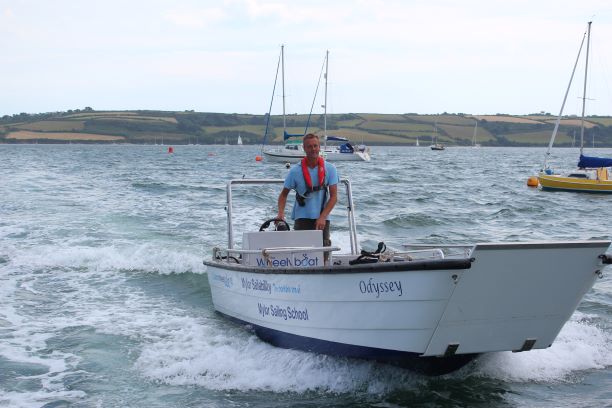 man driving accessible powerboat at Mylor Sailability Falmouth Cornwall GOOD DAY PROMISE