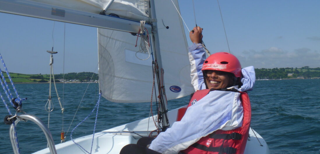 Girl sailing on dinghy wearing a helmet