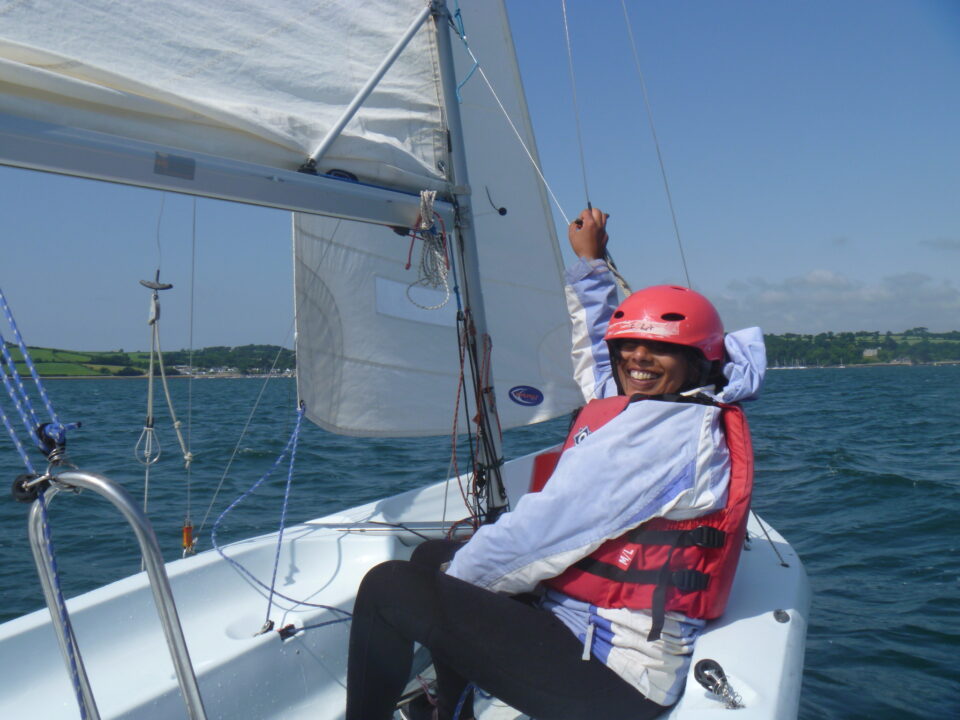 Girl sailing on dinghy wearing a helmet