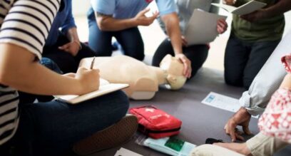 adults sat on the floor taking training for first aid