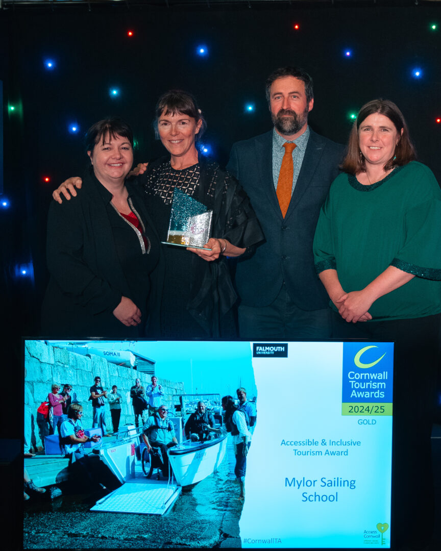 mylor sailing school staff with the awards ceremony tourism board colleagues standing in front of a lit up screen