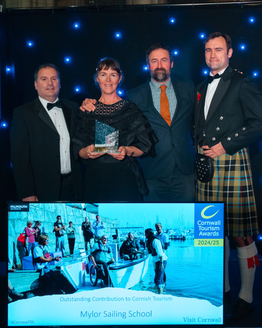 mylor sailing school staff with the awards ceremony tourism board colleagues standing in front of a lit up screen